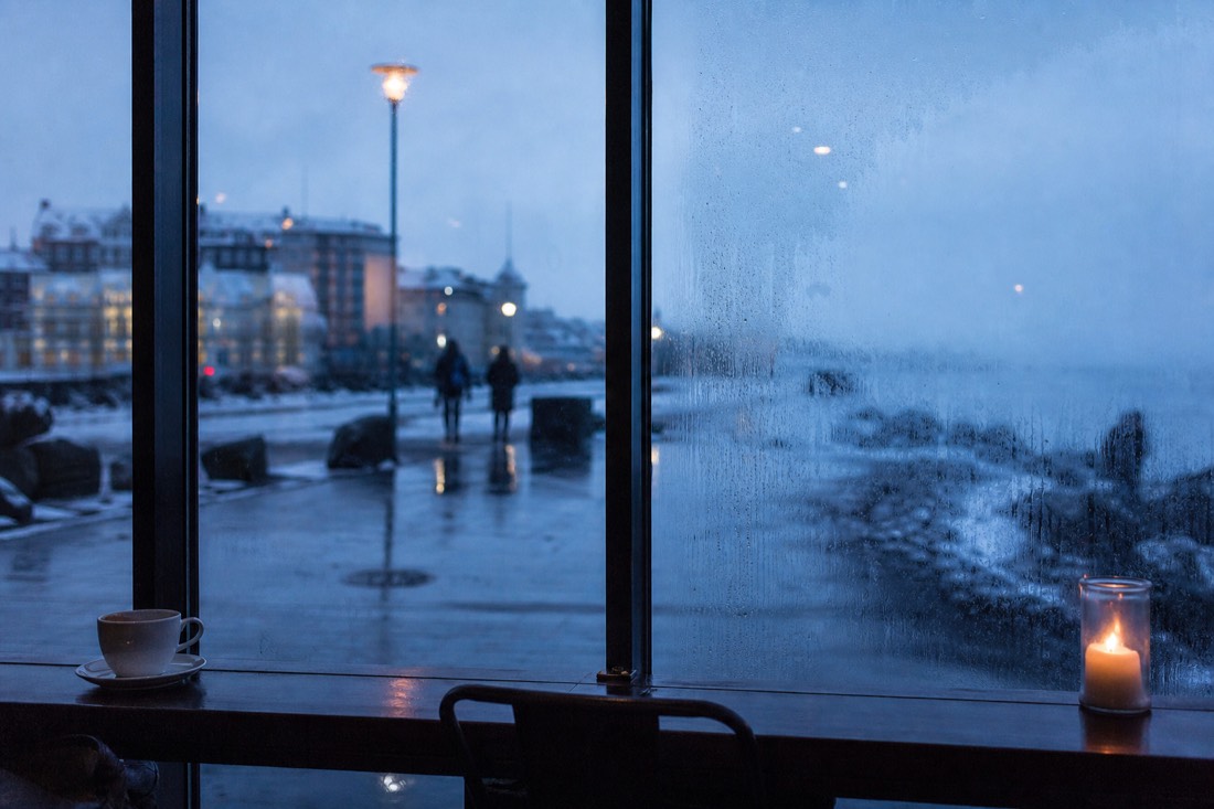 Cafe window seat in Reykjavik with condensation on the glass and rain running outside
