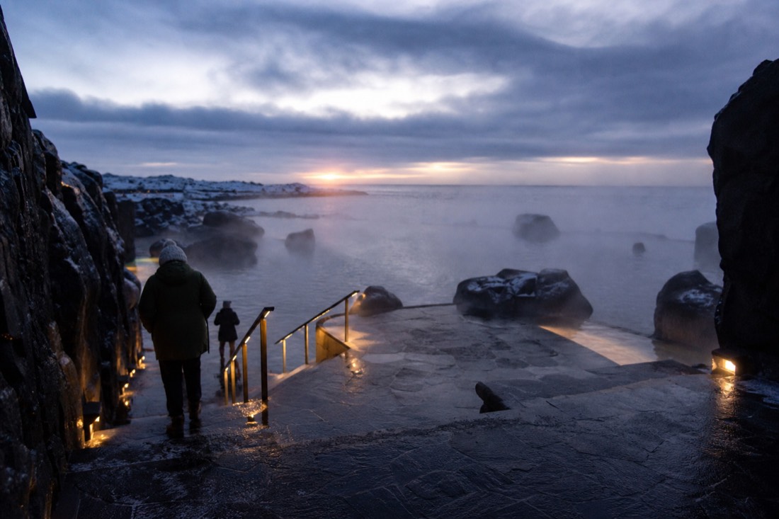 Steam rising from the Sky Lagoon terrace on a dark Icelandic winter evening